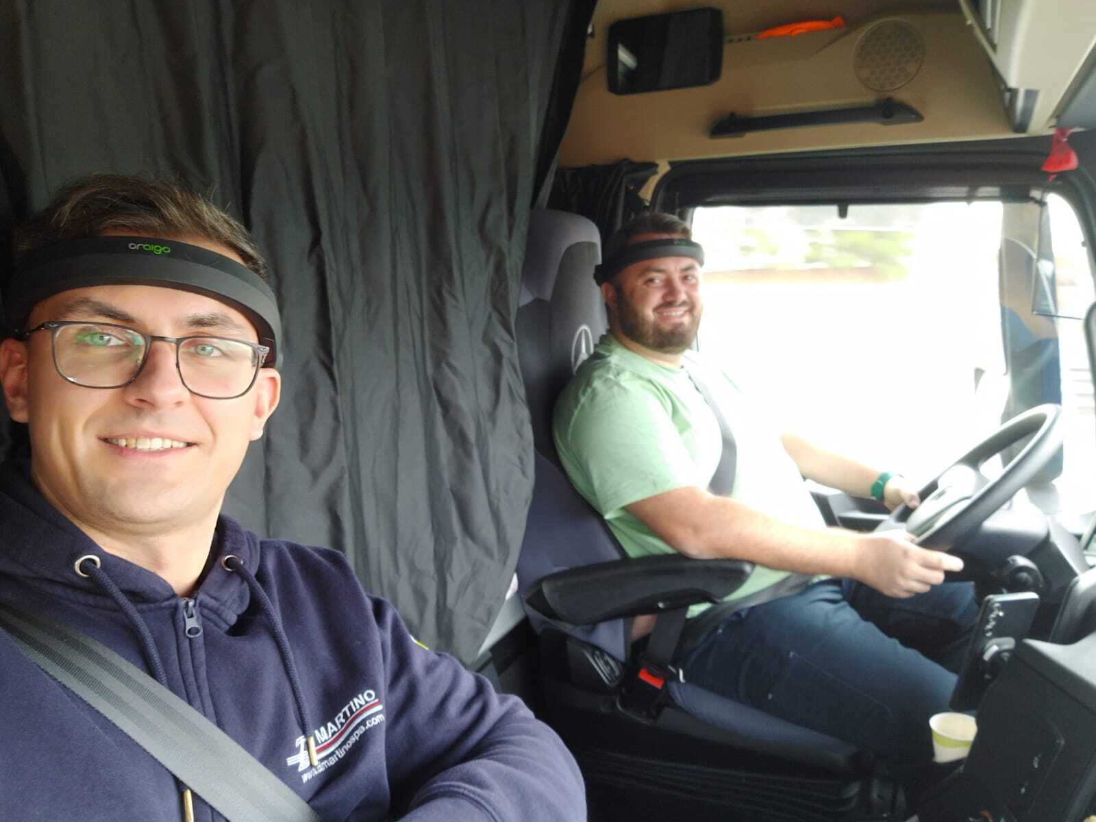 Two professional drivers transport hazardous materials while wearing Aigo, a device for monitoring driver fatigue and drowsiness.